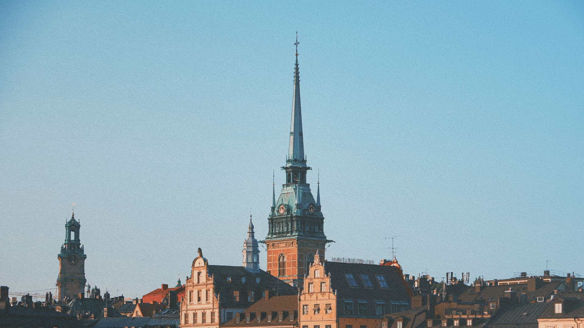 Maisons rouges traditionnelles au bord de l'eau à Hälsingland, créant une scène paisible et idyllique.
