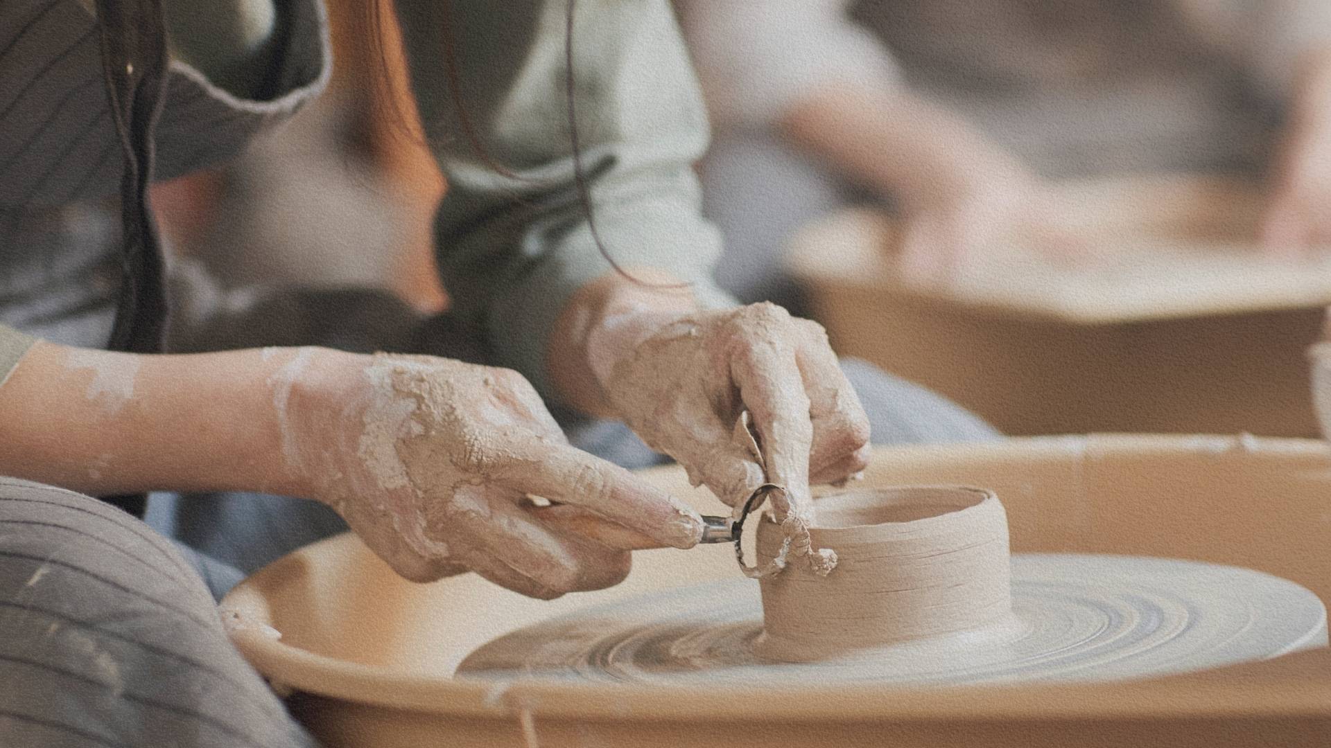 Artisan japonais façonnant un bol en céramique sur un tour, geste précis et concentration silencieuse