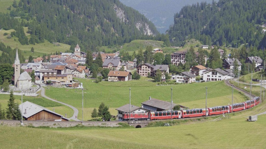 Village de Bergün dans le canton des Grisons avec train de la ligne rhétique traversant la vallée alpine