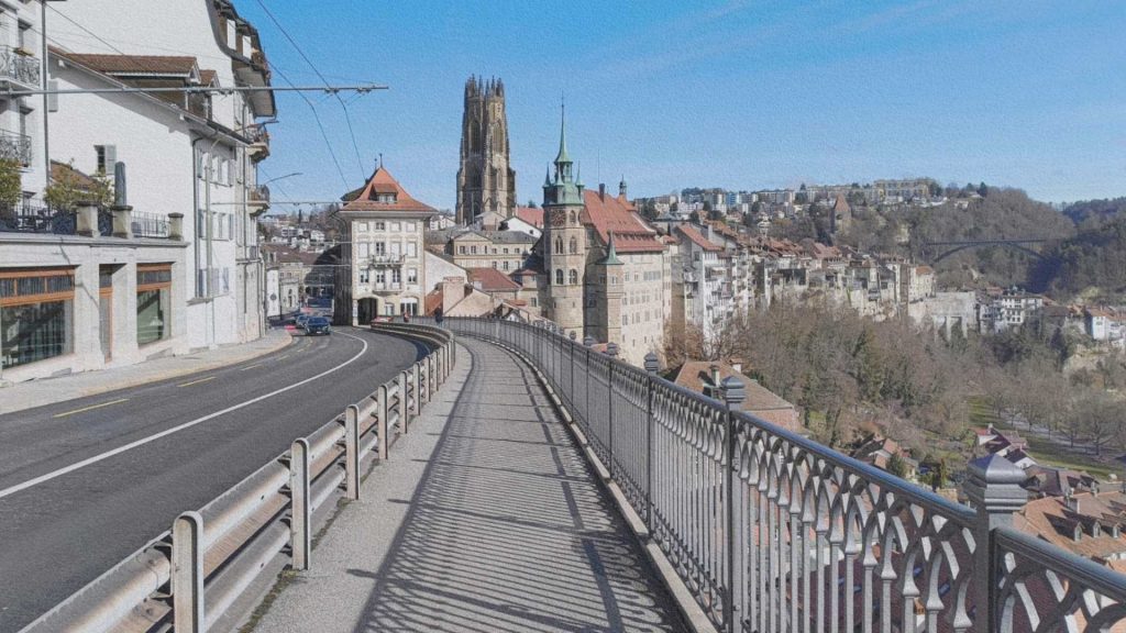 Vue depuis la ville haute de Fribourg avec la cathédrale Saint-Nicolas, les façades anciennes et le relief qui structure la ville