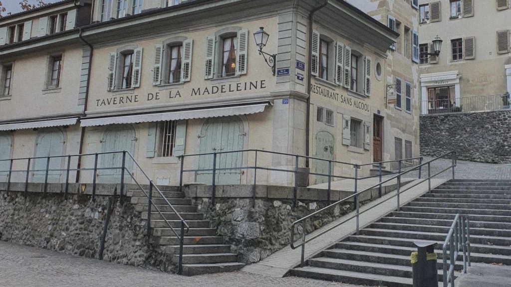 Façade de la Taverne de la Madeleine dans la vieille ville de Genève, avec escaliers en pierre et bâtiments anciens