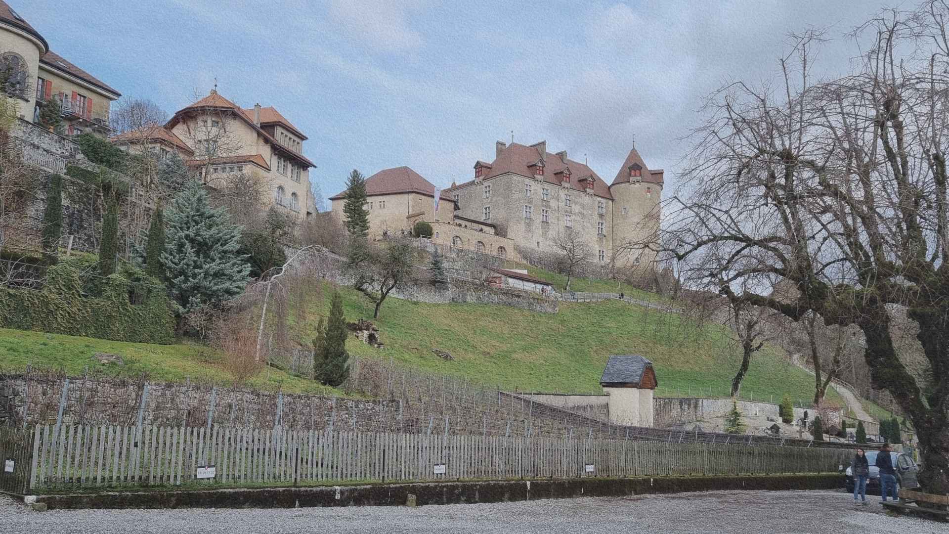 Château de Gruyères dominant la pente et les anciennes terres agricoles, montrant la position stratégique du village