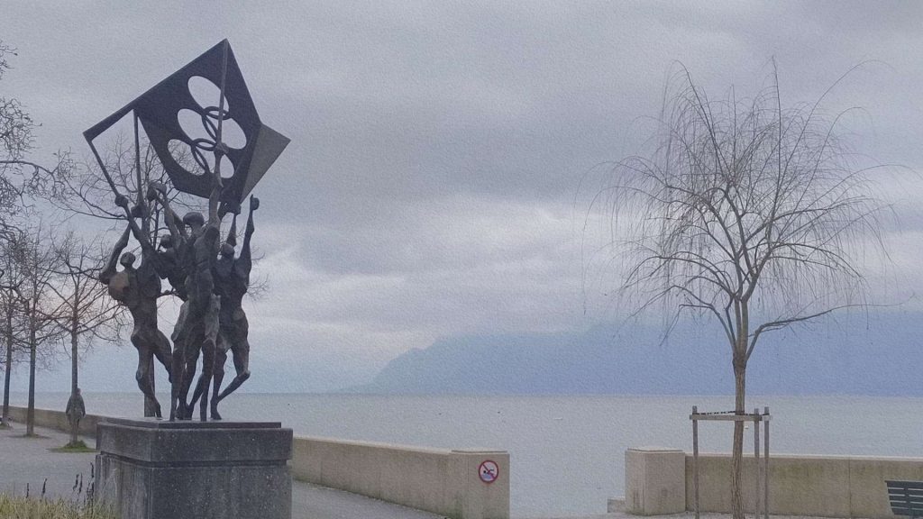 Sculpture moderne sur les quais d’Ouchy à Lausanne face au lac Léman, avec les Alpes visibles à l’horizon