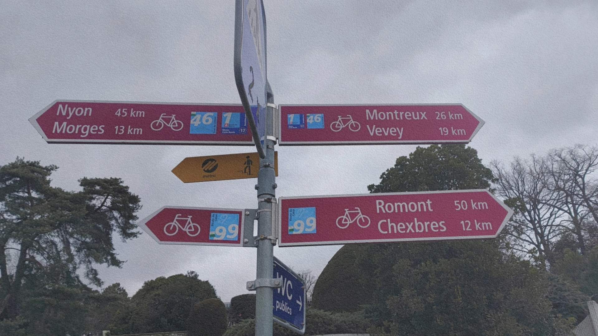 Panneaux de signalisation cyclable à Lausanne indiquant les directions de Montreux, Vevey, Nyon et Morges au bord du lac Léman