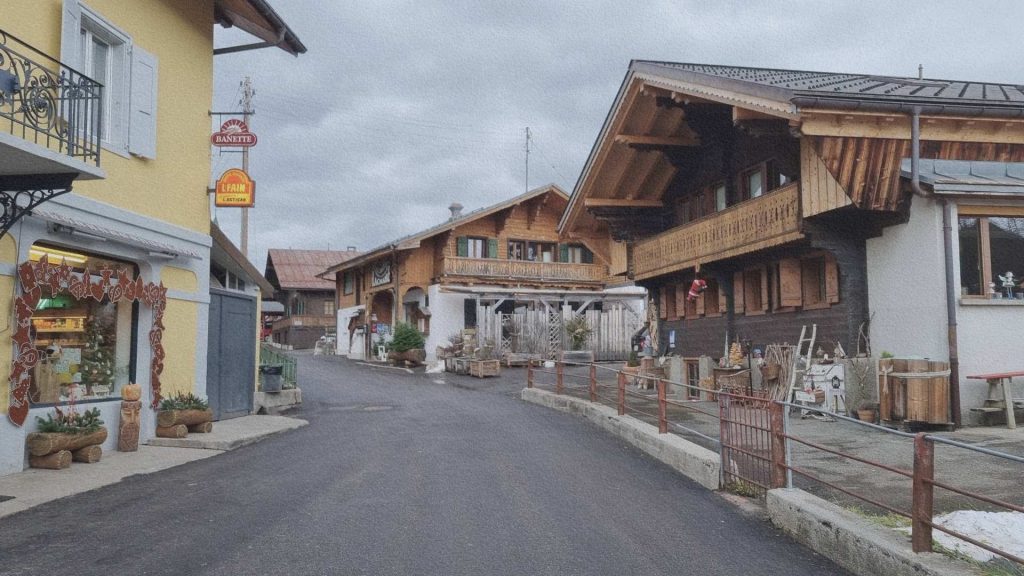 Rue du centre de Leysin avec chalets en bois, commerces et architecture alpine traditionnelle dans un village de montagne suisse