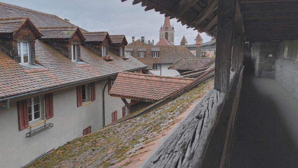 Remparts de Morat en Suisse vus depuis le chemin de ronde, avec toits anciens et clocher dominant la ville médiévale encore habitée