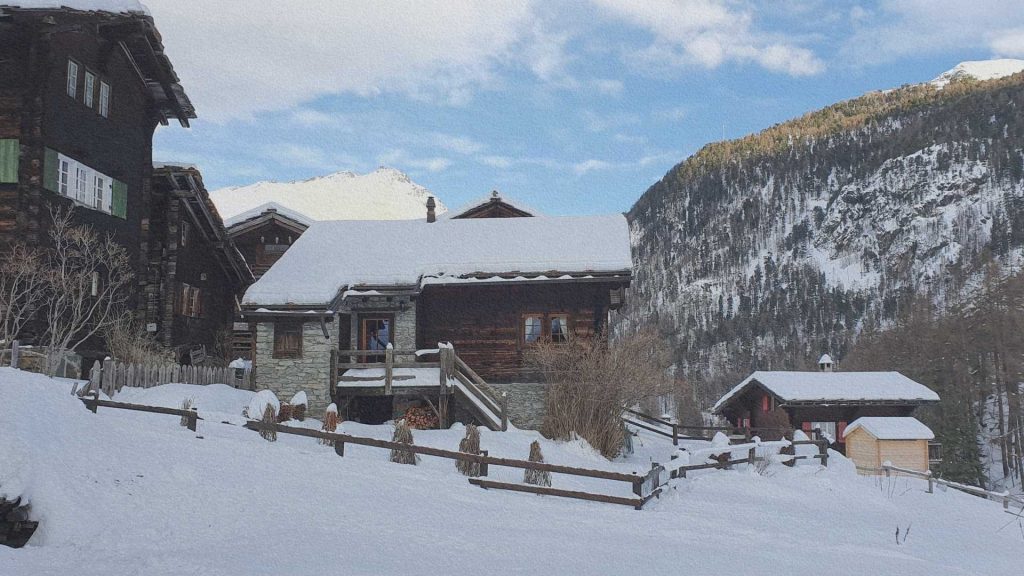 Chalets traditionnels en bois recouverts de neige dans un hameau de Zermatt, Alpes suisses