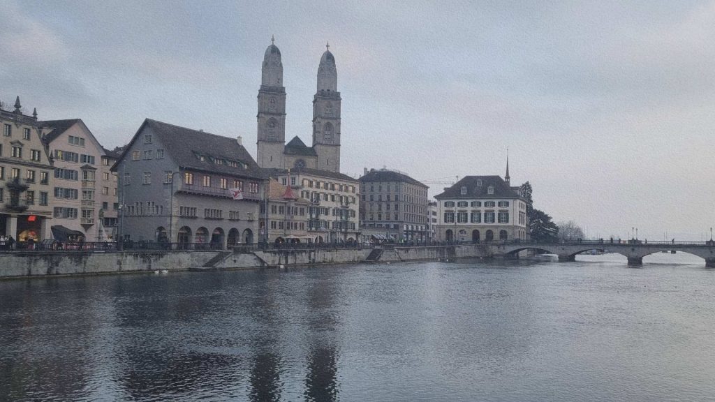 Zurich en Suisse avec la rivière Limmat, le pont historique et les tours de la Grossmünster en arrière-plan