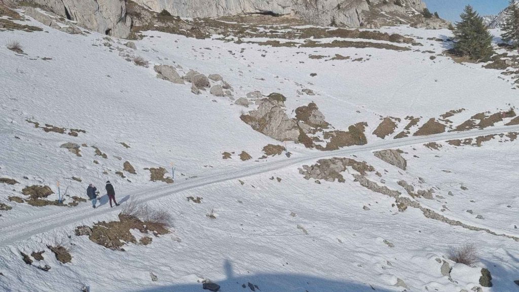 Sentier de montagne enneigé avec marcheurs dans les hauteurs de Leysin