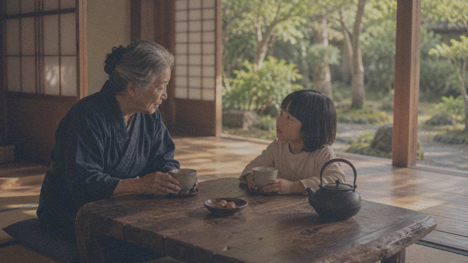 Grand-parent et enfant discutant autour d'un thé dans une maison traditionnelle japonaise ouverte sur un petit jardin.