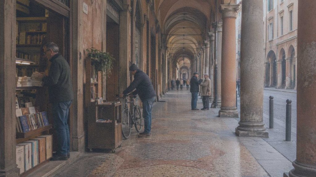 Une librairie ouvre ses portes sous les arcades historiques de Bologne, tandis que les habitants traversent naturellement le centre ancien.