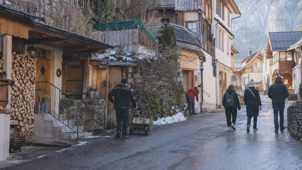 Livraison et déplacements ordinaires dans une rue étroite de Hallstatt pendant l’hiver.