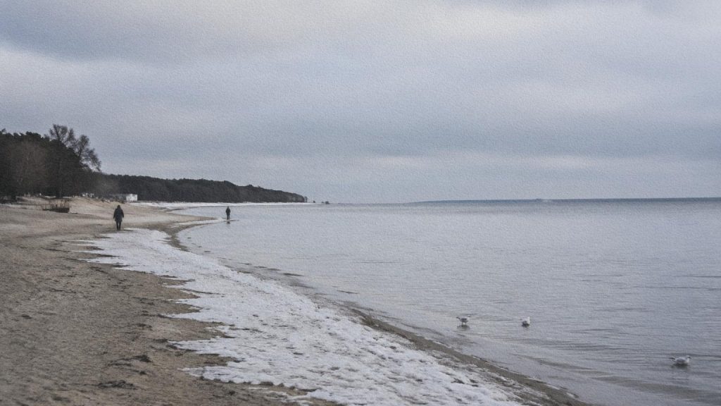 Deux personnes marchant sur la plage de Pirita au bord de la Baltique en hiver.