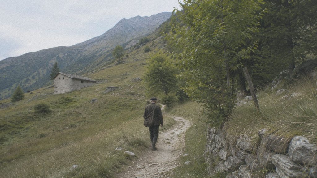 Homme marchant sur un chemin du Val Maira, évoquant les déplacements des caviè entre les villages au début du XXe siècle.