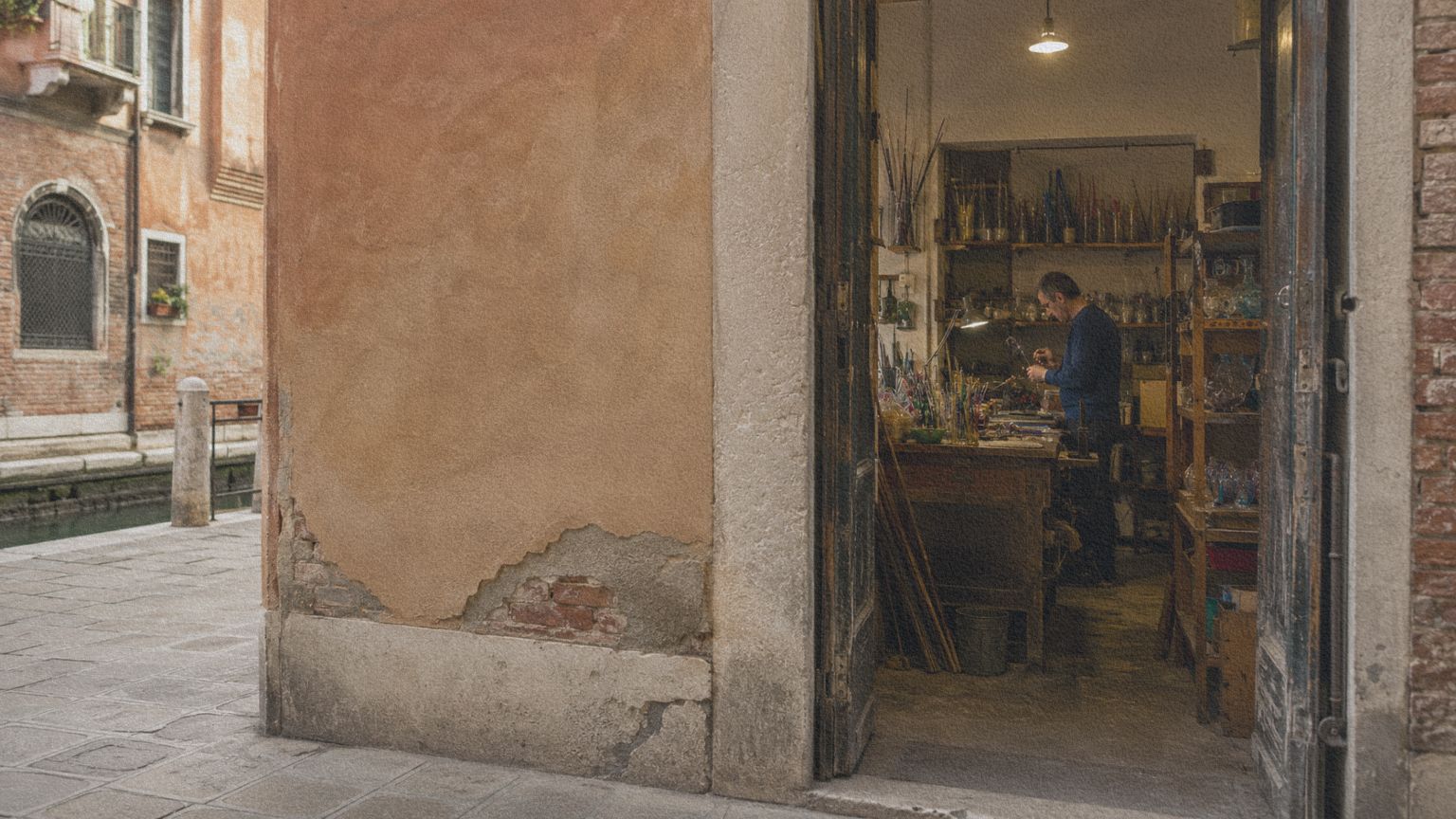 Atelier verrier ouvert sur une rue de Murano, montrant le travail artisanal derrière les objets en verre exposés dans les boutiques.
