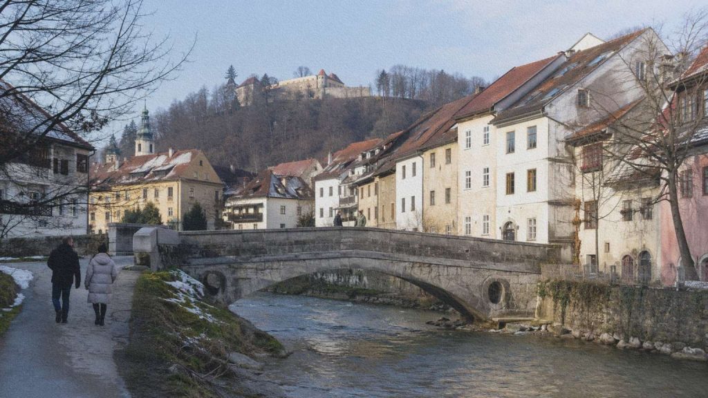 Habitants traversant le pont des Capucins sur la Sora à Škofja Loka en hiver.