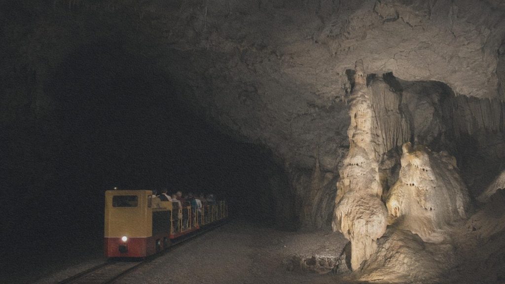Le train souterrain de Postojna traverse une vaste galerie calcaire éclairée avec sobriété.